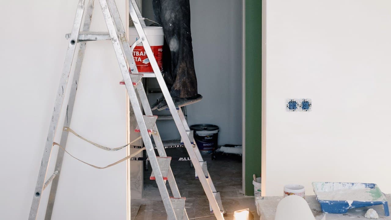 A ladder and paint tins in a room mid-renovation